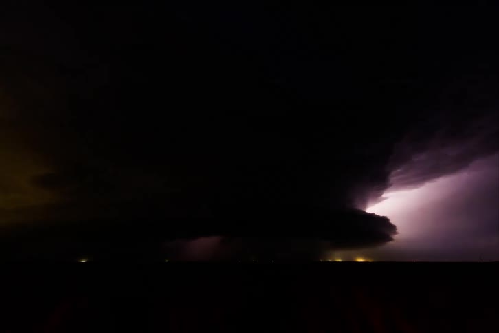 Time lapse of cars driving under dark storm clouds and lightning
