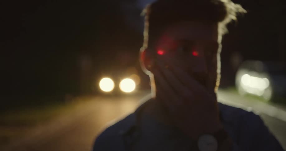 A man is standing outdoors at night