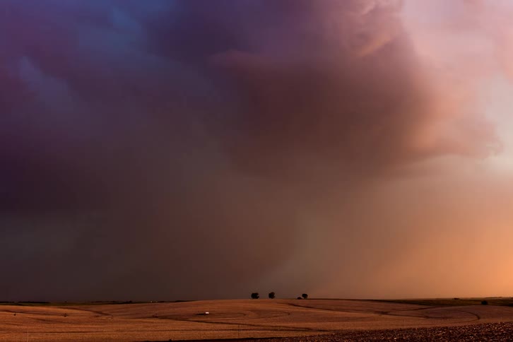 Time lapse of storm clouds and lightning rolling over prairie land