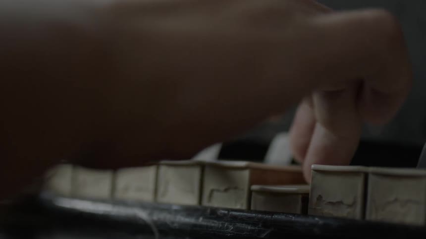 Close up of a person's hand as they play a piano