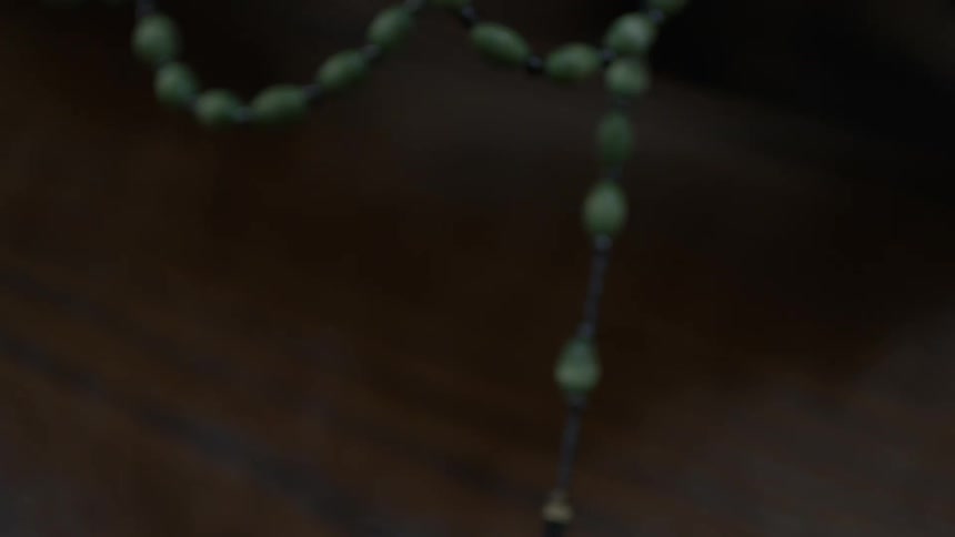 A rosary bead is swinging