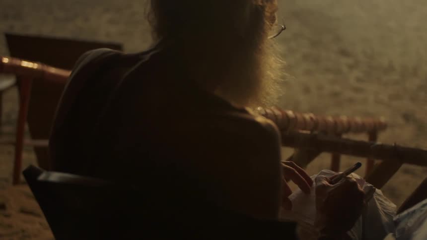 Woman sitting outside on a chair writing in a notebook
