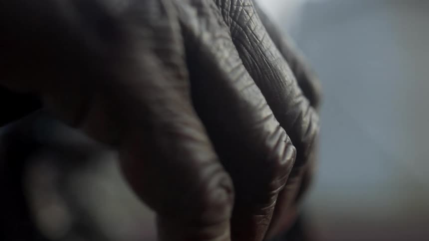 A persons hand resting on a cane