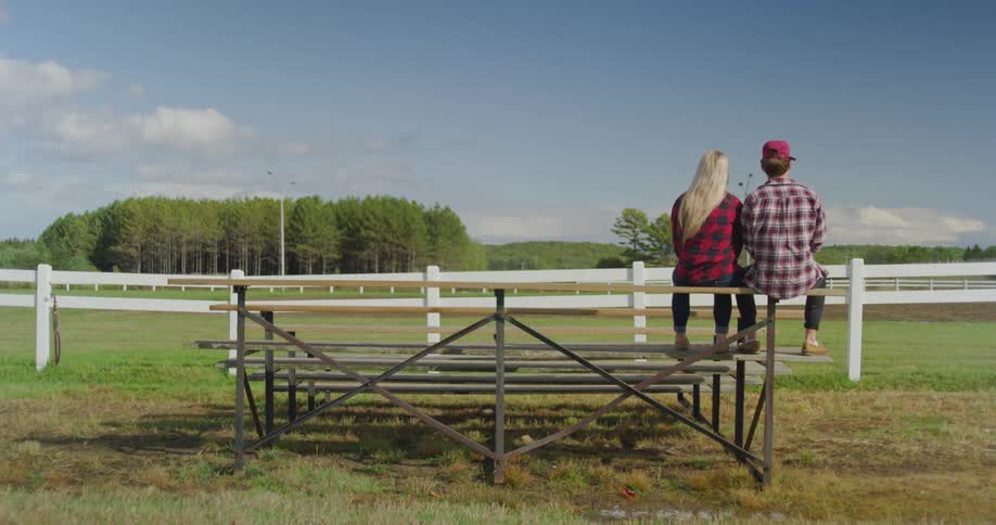 Couple sitting on a bench looking over a field
