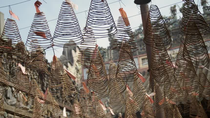Spiral shaped metal art hanging from a string outside at a historical site