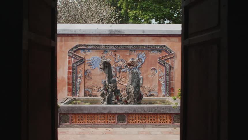 A water fountain with two statues is located in an outdoor courtyard