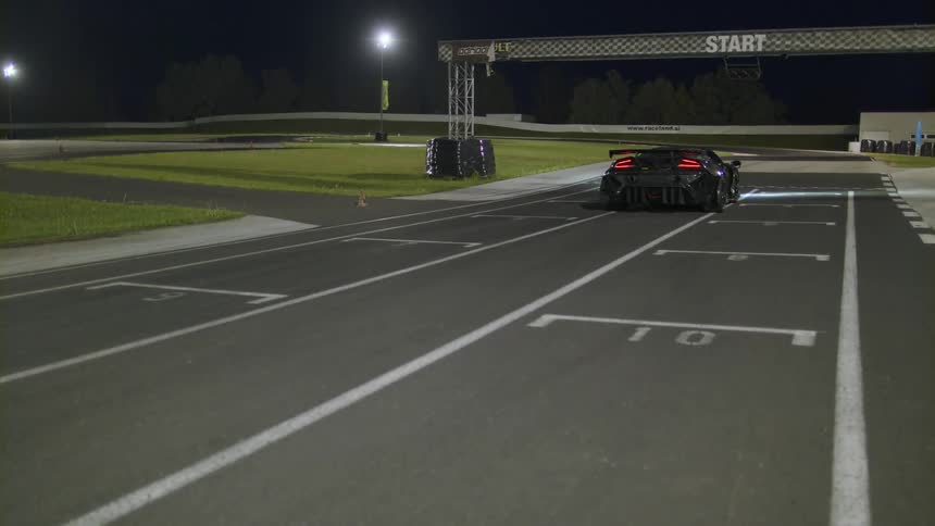 Sports car on a race track at night waiting at the start line