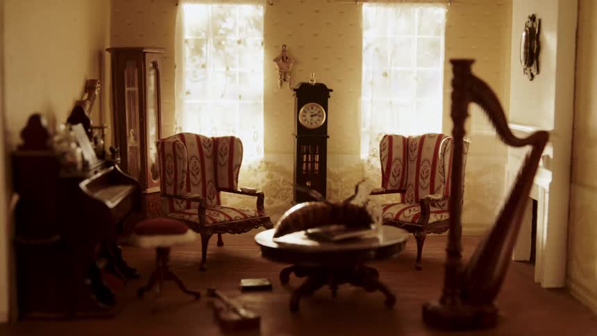 A cockroach struggles to flip itself over in a dollhouse living room
