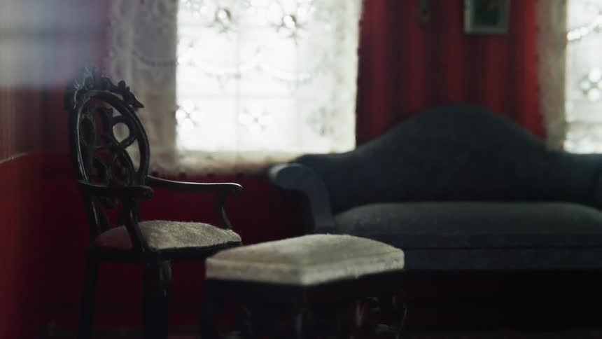 Miniature living room with a sofa and a chair inside of a doll house