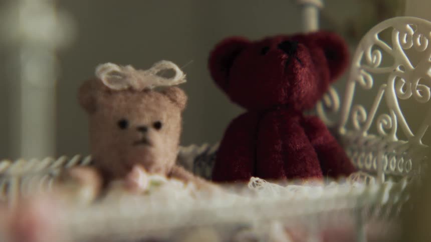 Miniature stuffed animals inside of a small baby crib