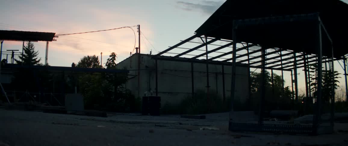 Sun setting behind a building in an empty town