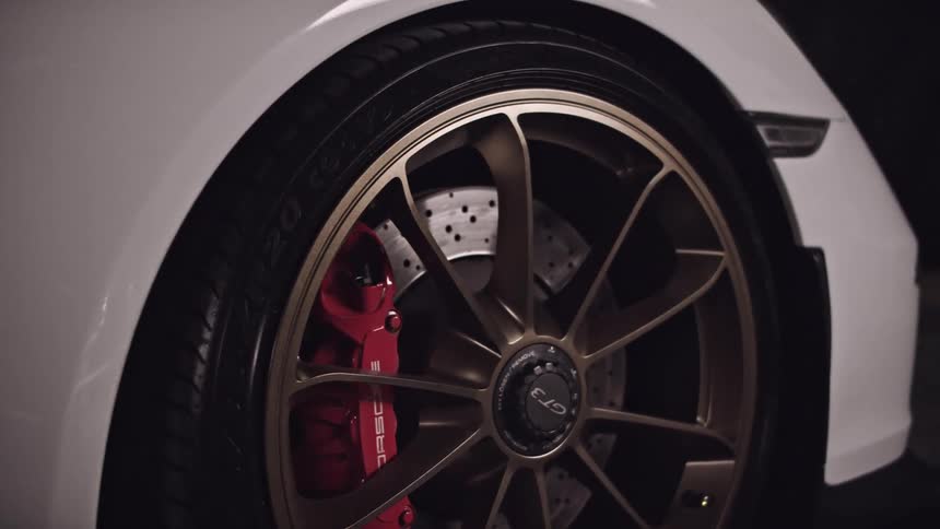 Close up of the side of a white shiny car and its tire and rim