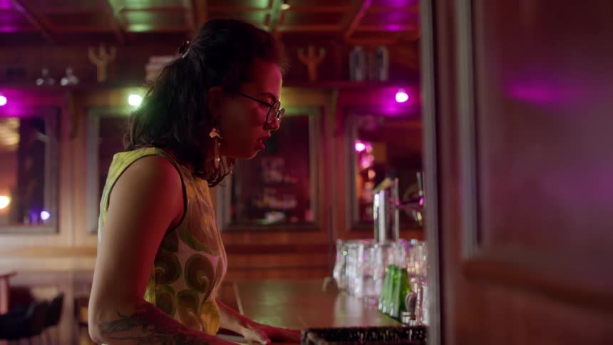 Woman standing inside at a bar having a panic attack