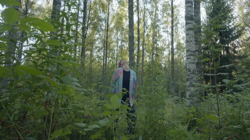 Female dancer performing slow dance moves in a forest