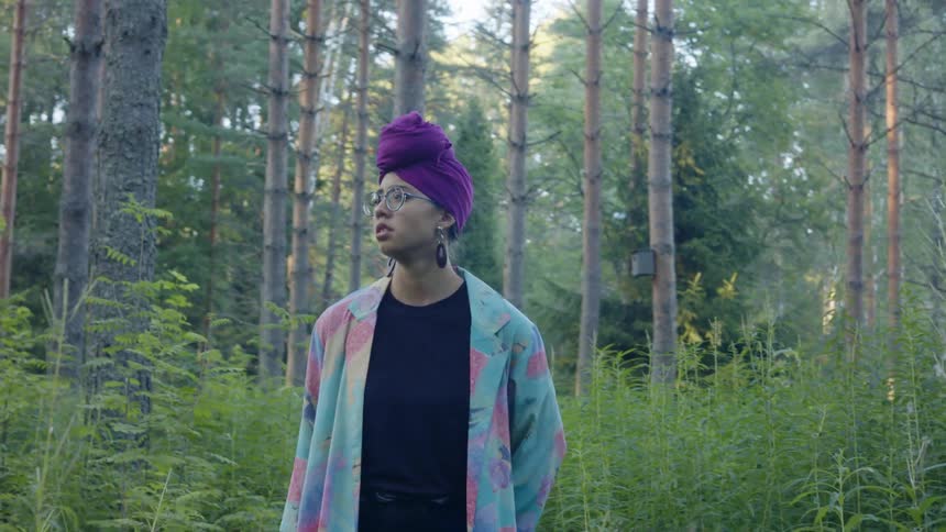 Woman standing in a forest at day time looking around