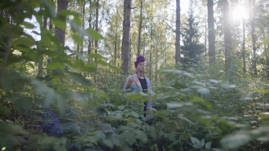 A stands up in a forest in daylight