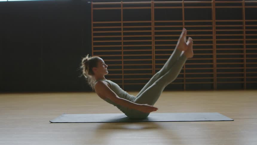 Woman does yoga poses in an empty yoga studio