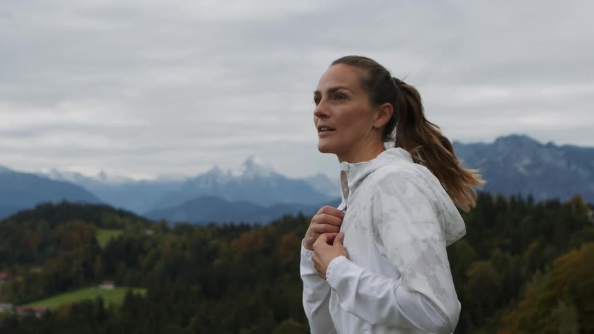 Woman staring off at a mountain range preparing to exercise