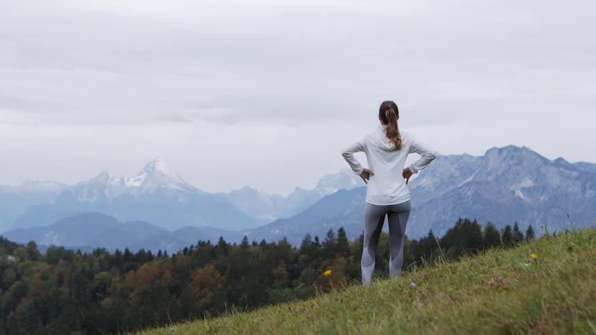 Woman running and stops to look at view of mountains