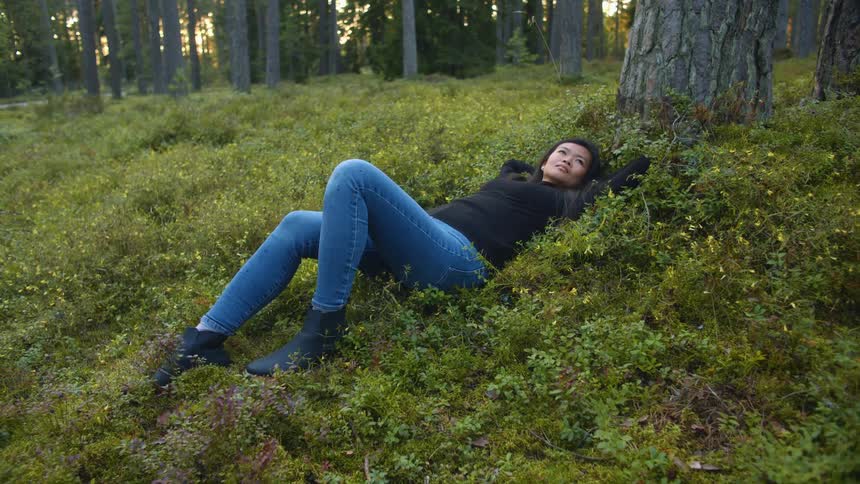 Woman lying in a forest