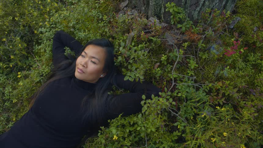 A woman is laying in the grass