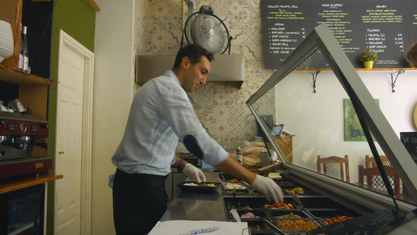 Restaurant worker puts together meal for customer