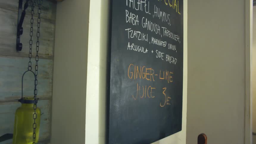 Restaurant menu on a chalk board mounted on the wall