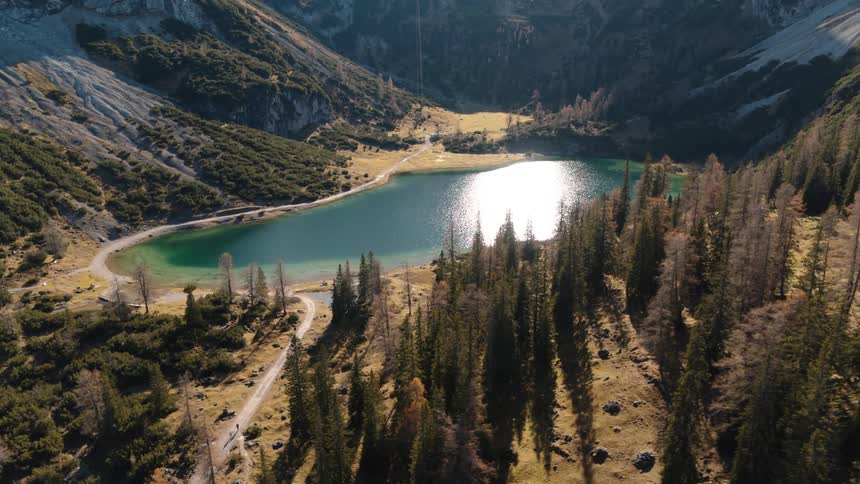 A lake in the middle of mountains with snow with sunlight and blue skies