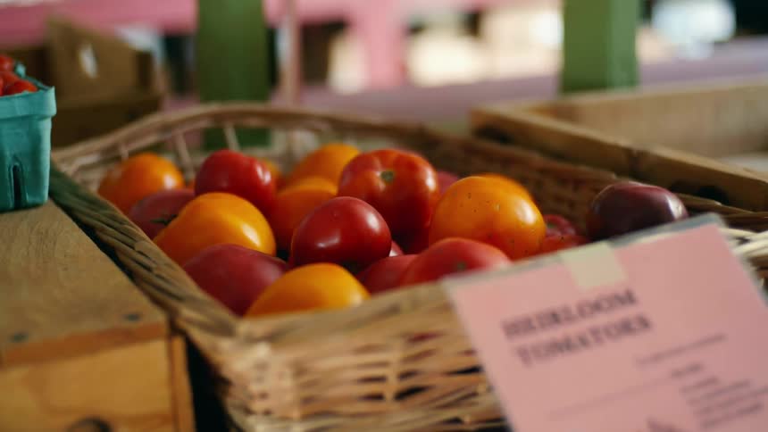 A basket of heirloom tomatoes at an outdoor market