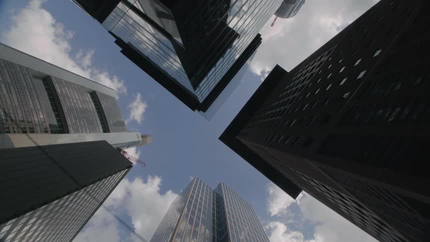 Skyscrapers of different heights and materials fill a city block