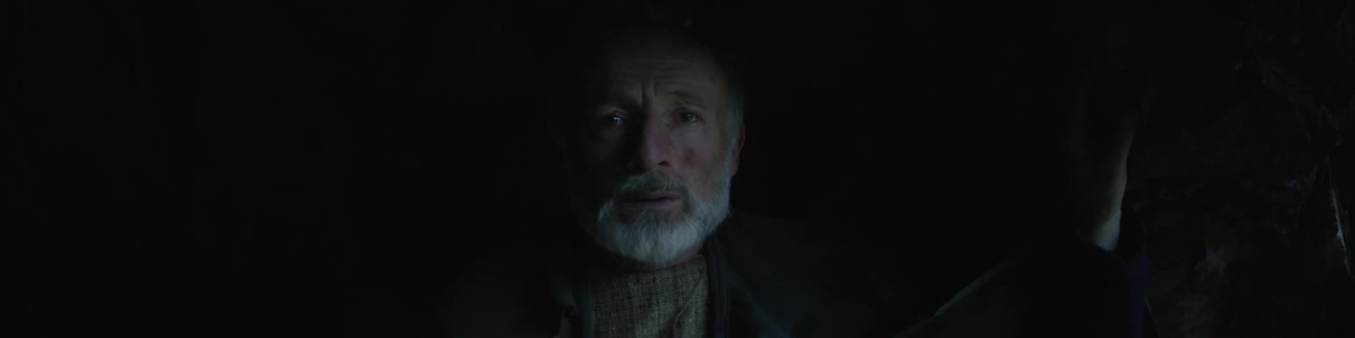 Worried looking older man sitting in the dark