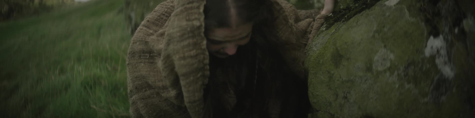 A woman is climbing down some rocks crying
