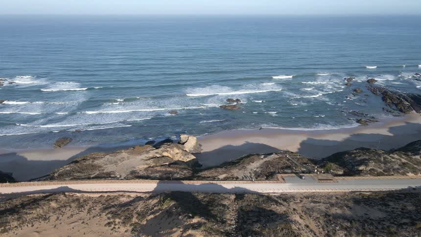 Aerial view of ocean waves breaking against the beach
