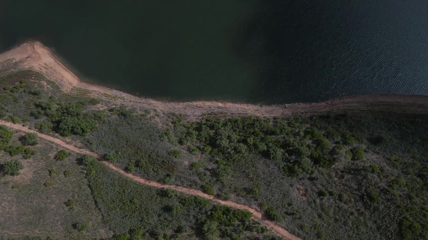 House on top of a hill in a remote location next to a large river where it connects to another side