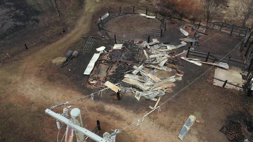 A small building has collapsed and the ground near a farm is charred from a fire
