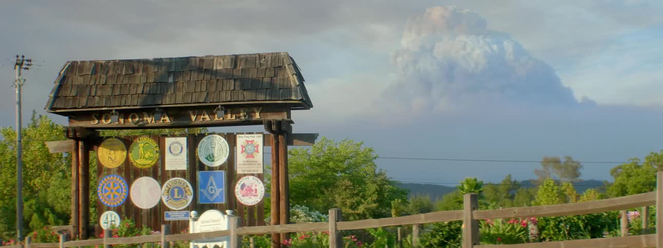 A wooden kiosk is covered with emblems at a national park