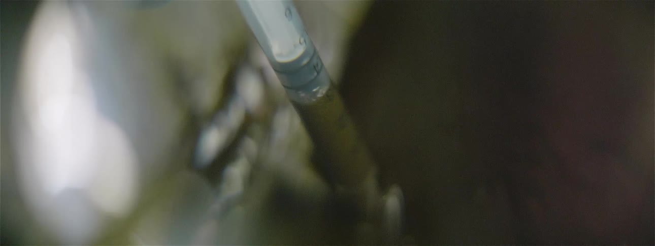 Person wearing gloves draws fluid up in oral syringe