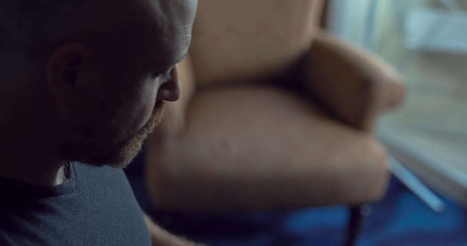 A man is sitting while he uses a smartphone