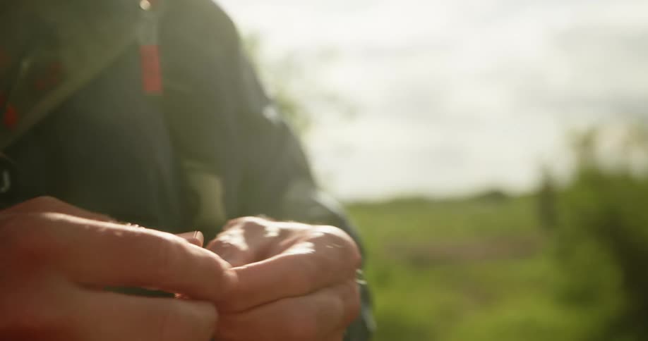 Man holding a piece of string and crafting outside
