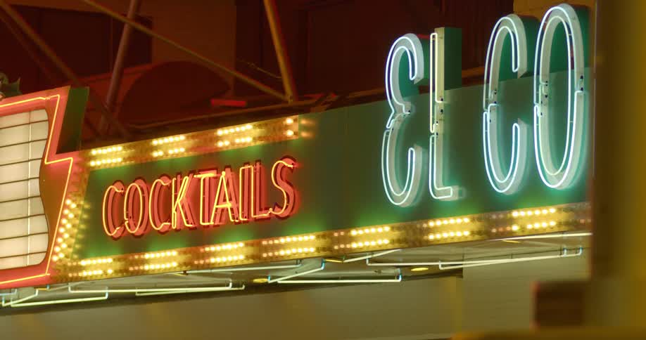 Neon signs glow above marquee lights