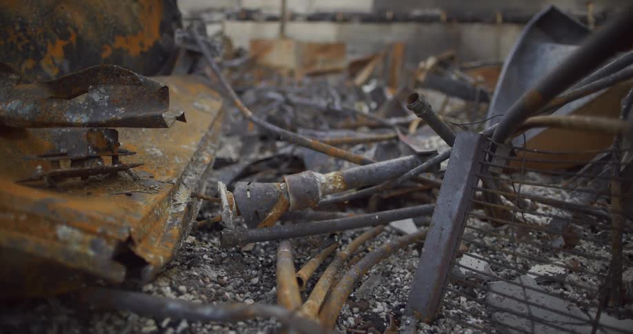 A factory floor is covered with discarded parts and rusted metal