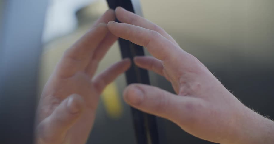 Womans hand touches the a mirror outdoors