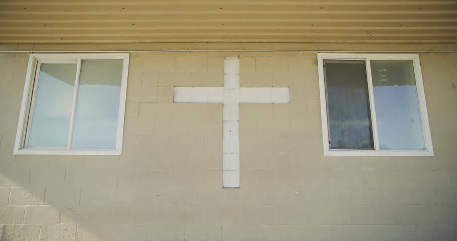 Cross between two windows on a building outdoors