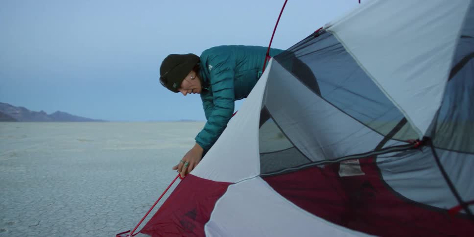 A woman setting up a tent