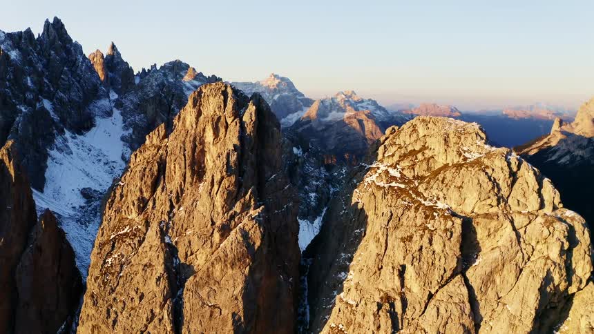 A snow strewn mountain range during the day