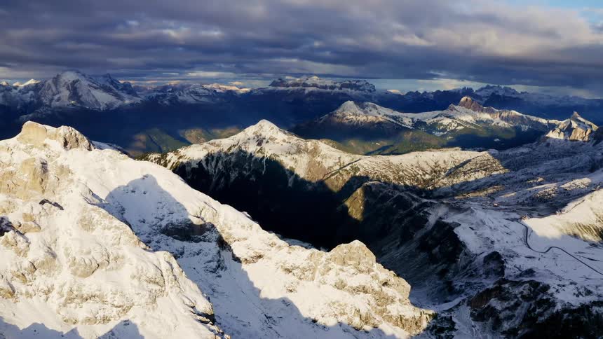 A mountain range with snow and ice with dark clouds
