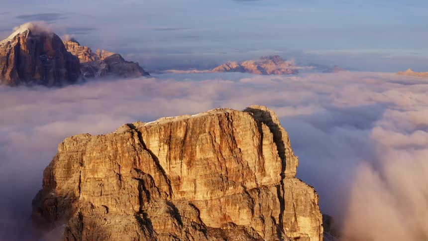 An aerial view of mountain tops with clouds and sunlight