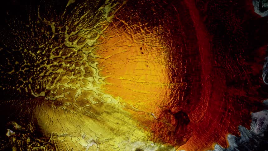 Red orange and yellow texture liquids moving through a liquid