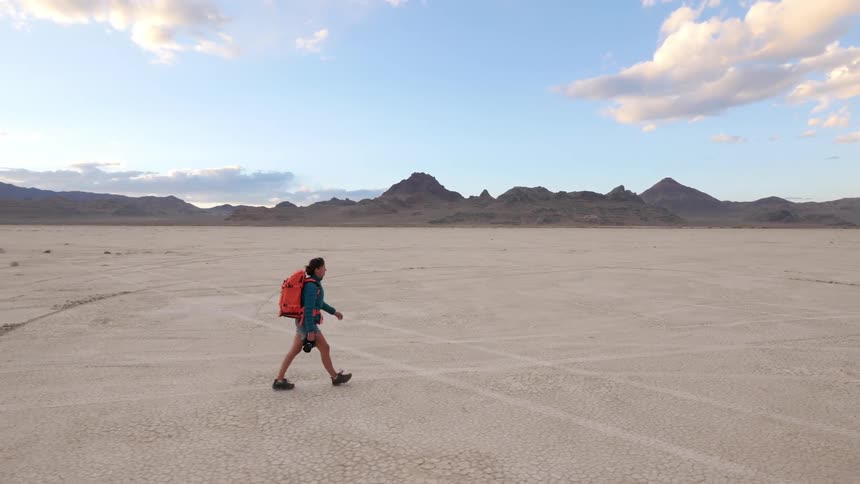 A woman backpacks through the desert