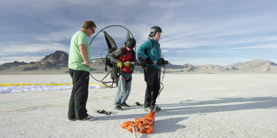 Two men are setting up to go parasailing